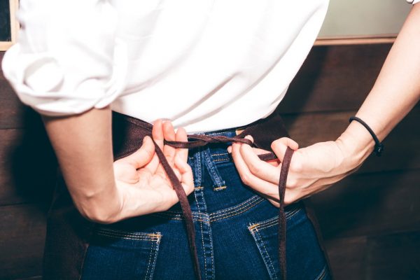 Server tying her restaurant server apron