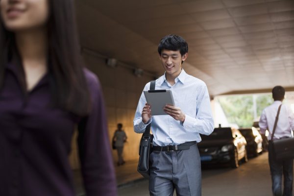 Businessman holding is iPad while on the job, iPad carrying cases concept