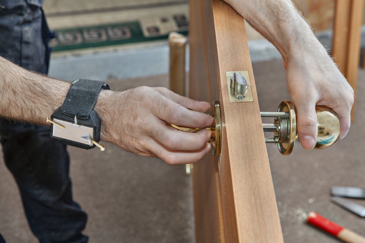 carpenter-with-magnetic-wristband-installing-lock-on-door