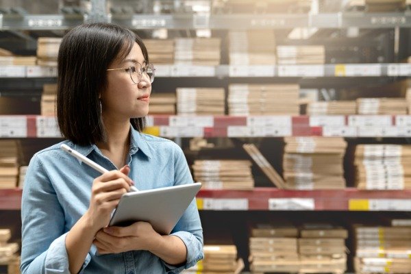 female-worker-holding-a-tablet-computer-in-a-warehouse-inventory-shrinkage-concept